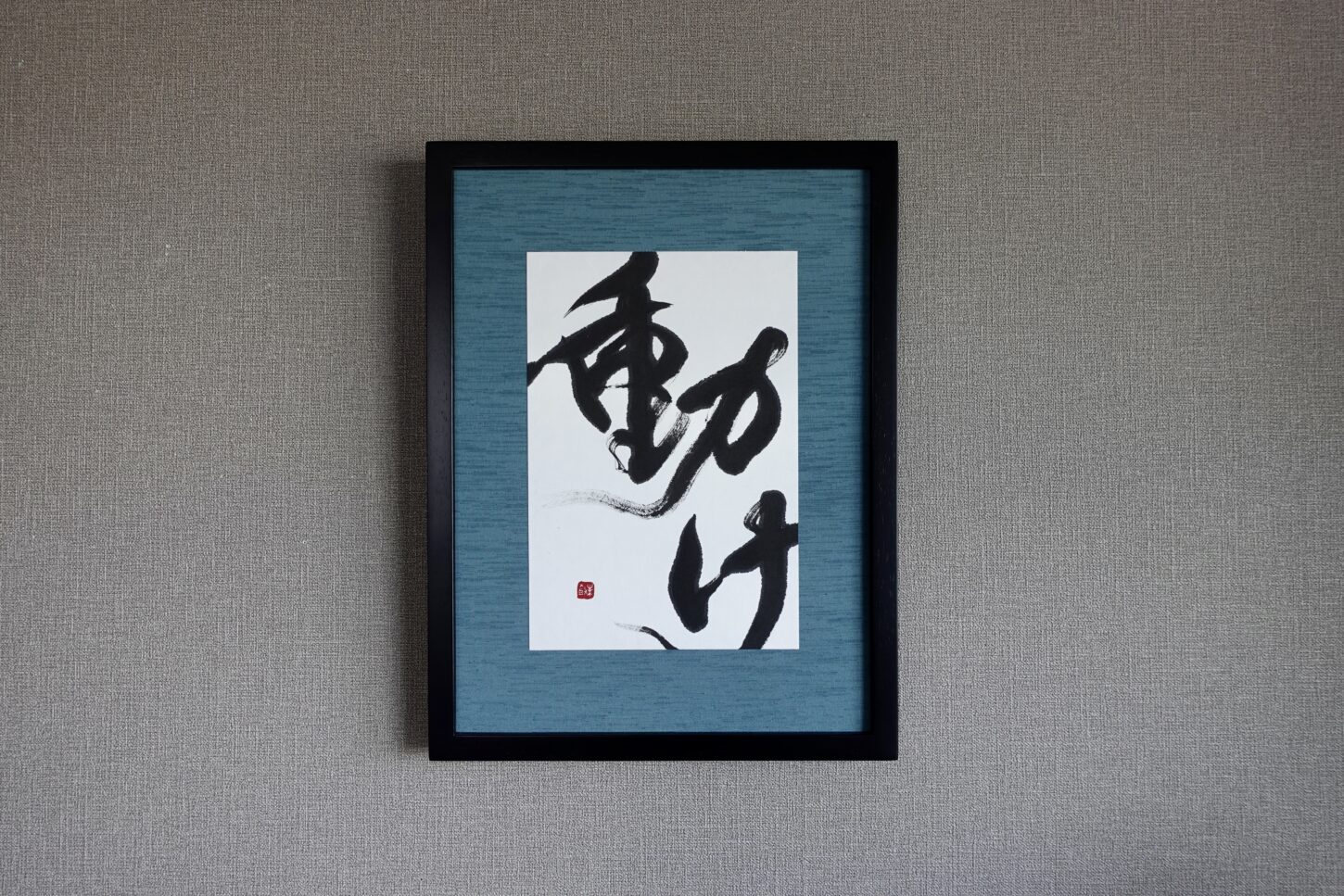 「動け」オーダーメイドの書道作品。力強く勢いのある書とインテリアに映えるカラーの額装で渋カッコイイ作品に。