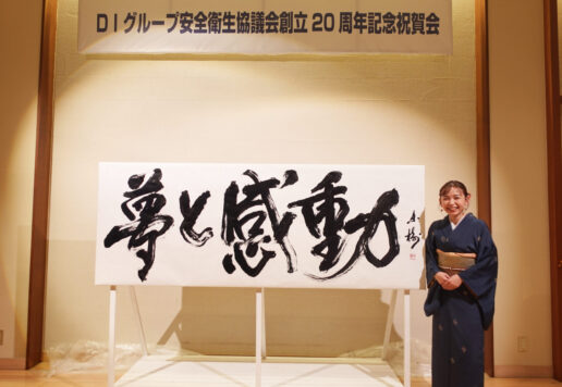 書家・根本みきが「DIグループ安全衛生協議会 創立20周年記念祝賀会」で、DIグループ代表・小板橋社長のモットー「夢と感動」を力強く揮毫する書道パフォーマンスを披露。参加者の夢が実り、感動が広がるよう願いを込めた作品。