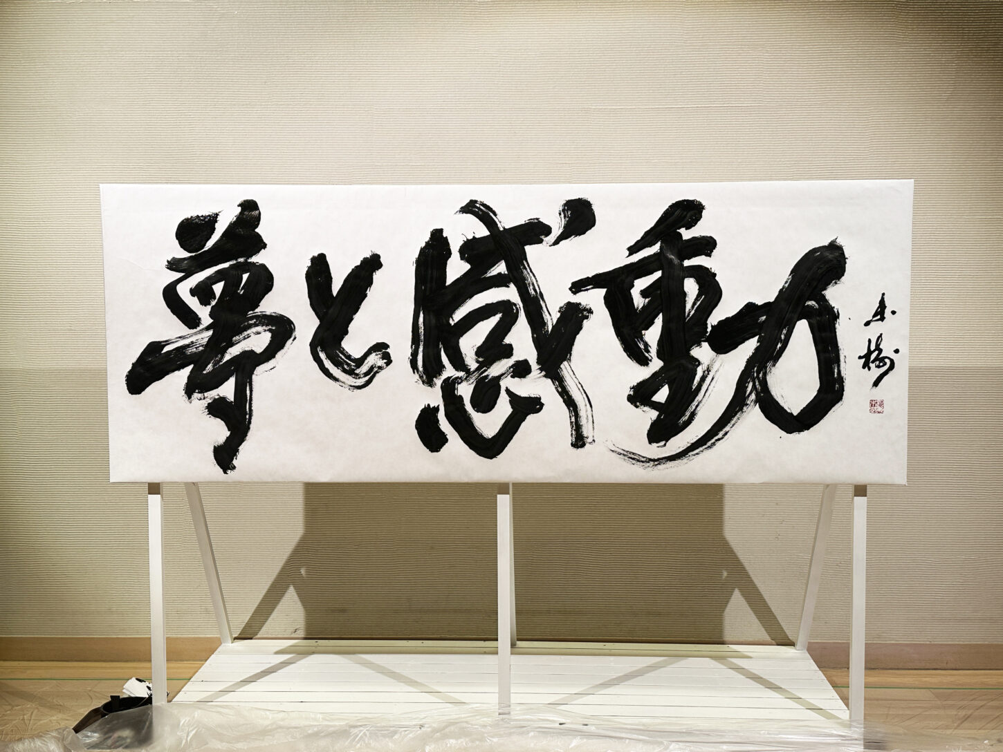 書家・根本みきが「DIグループ安全衛生協議会 創立20周年記念祝賀会」で、DIグループ代表・小板橋社長のモットー「夢と感動」を力強く揮毫する書道パフォーマンスを披露。参加者の夢が実り、感動が広がるよう願いを込めた作品。